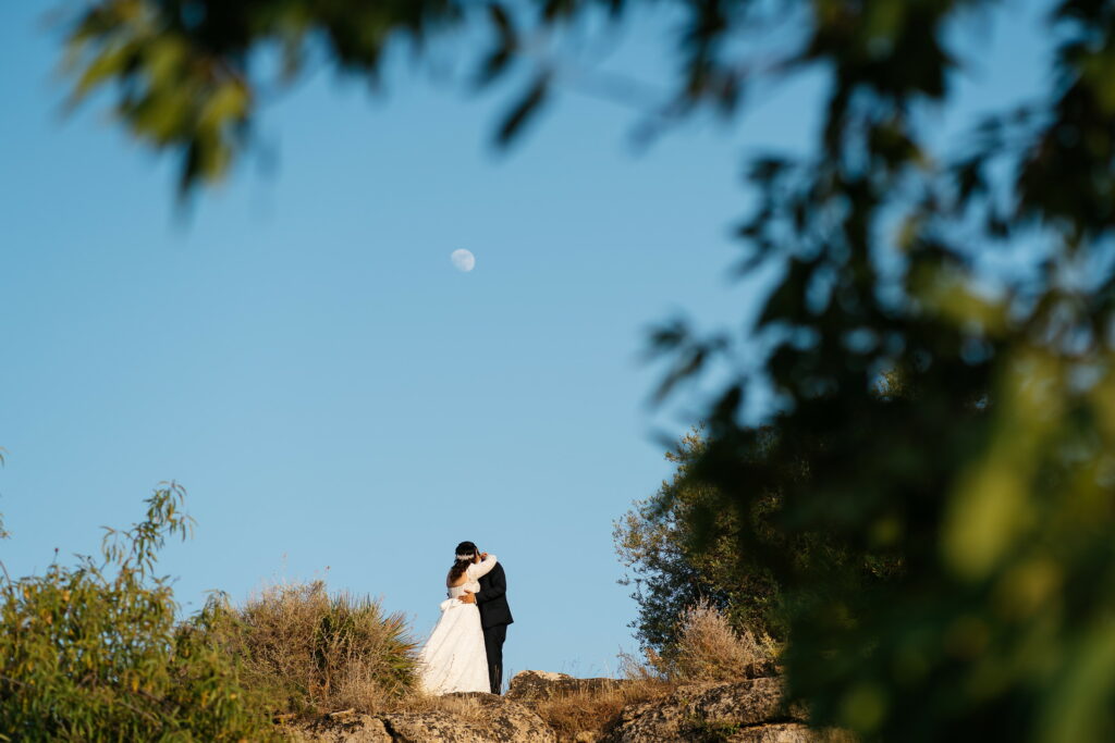 Photo of a couple in Sicily on a hill in the Valley of the Temples with the moon in the background
