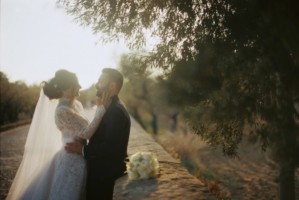 Foto della sposa con il marito, in un ritratto scattato a pellicola sulla Via Sacra, Valle dei Templi Agrigento. Fotografo Daniele Pullara.