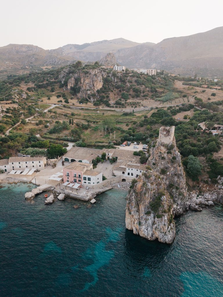 Drone view of Tonnara di Scopello between the sea, rocky coastline and the hills of Scopello