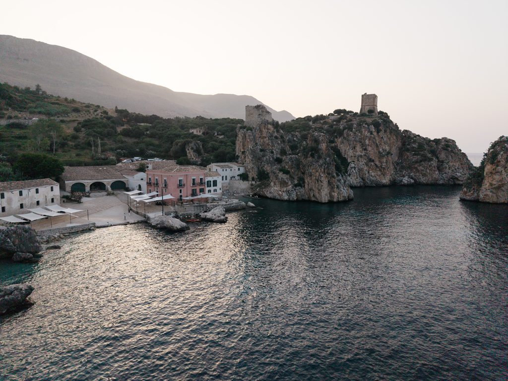 Tonnara di Scopello seen from the sea with its historic buildings, watchtower and bay